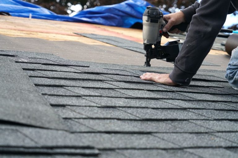 handyman using nail gun to install shingle to repair roof, Edina